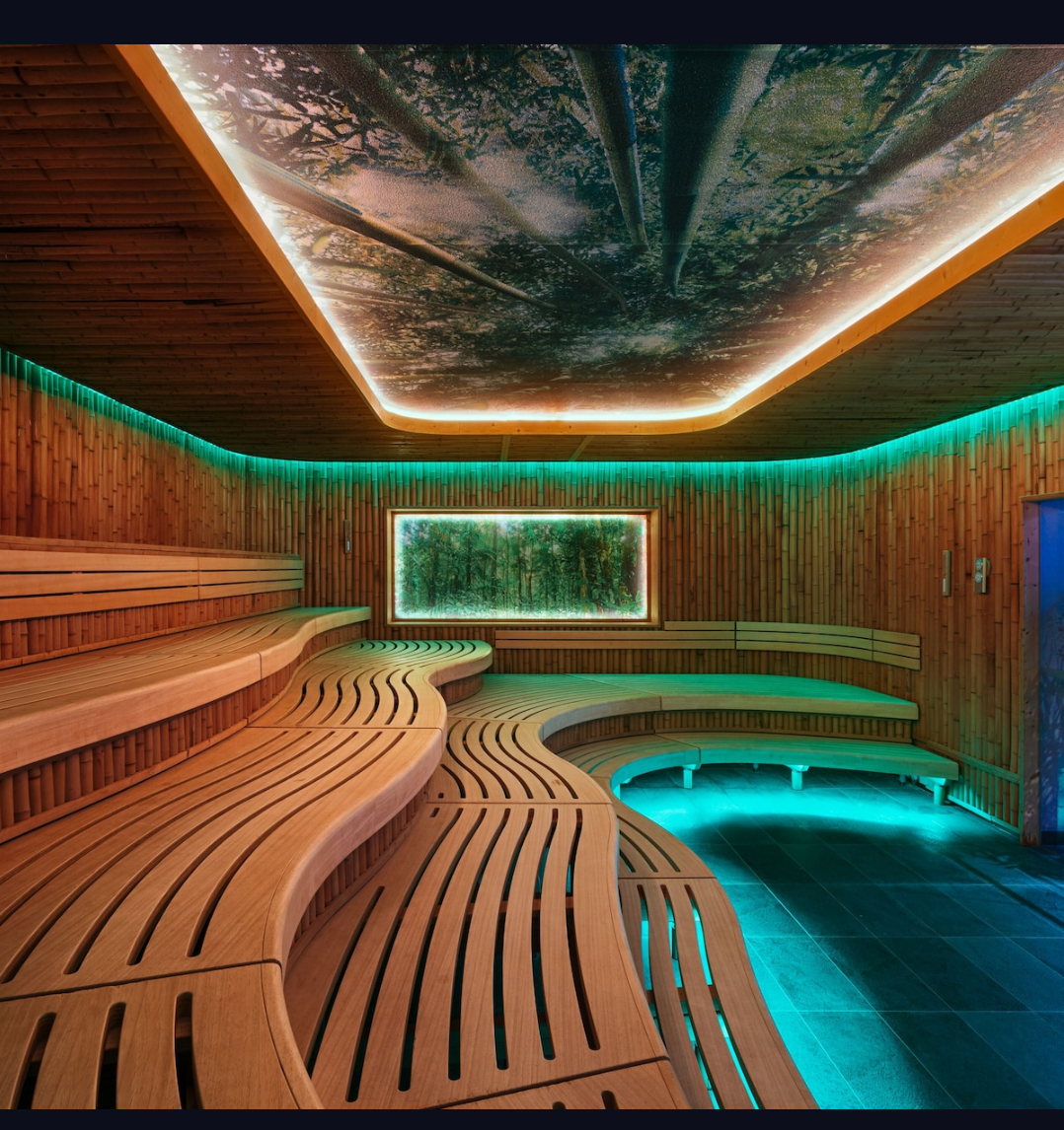 Eden sauna — sculpted cedar benches with ambient teal lighting and forest ceiling mural